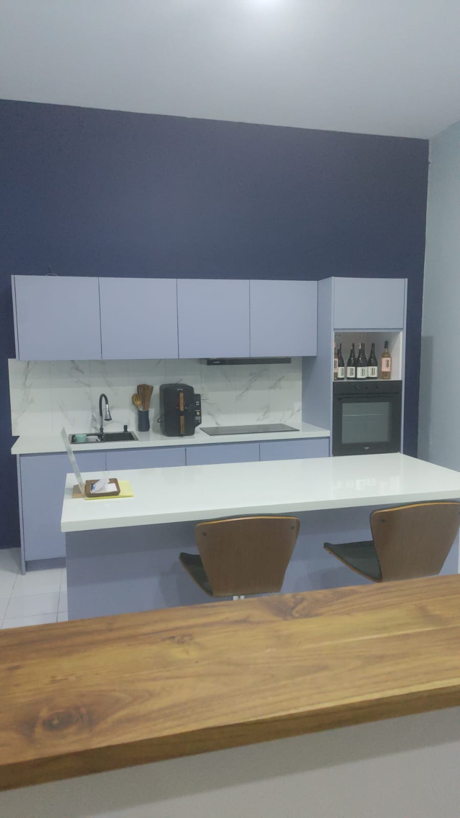 Contemporary compact kitchen with blue cabinets and marble backsplash