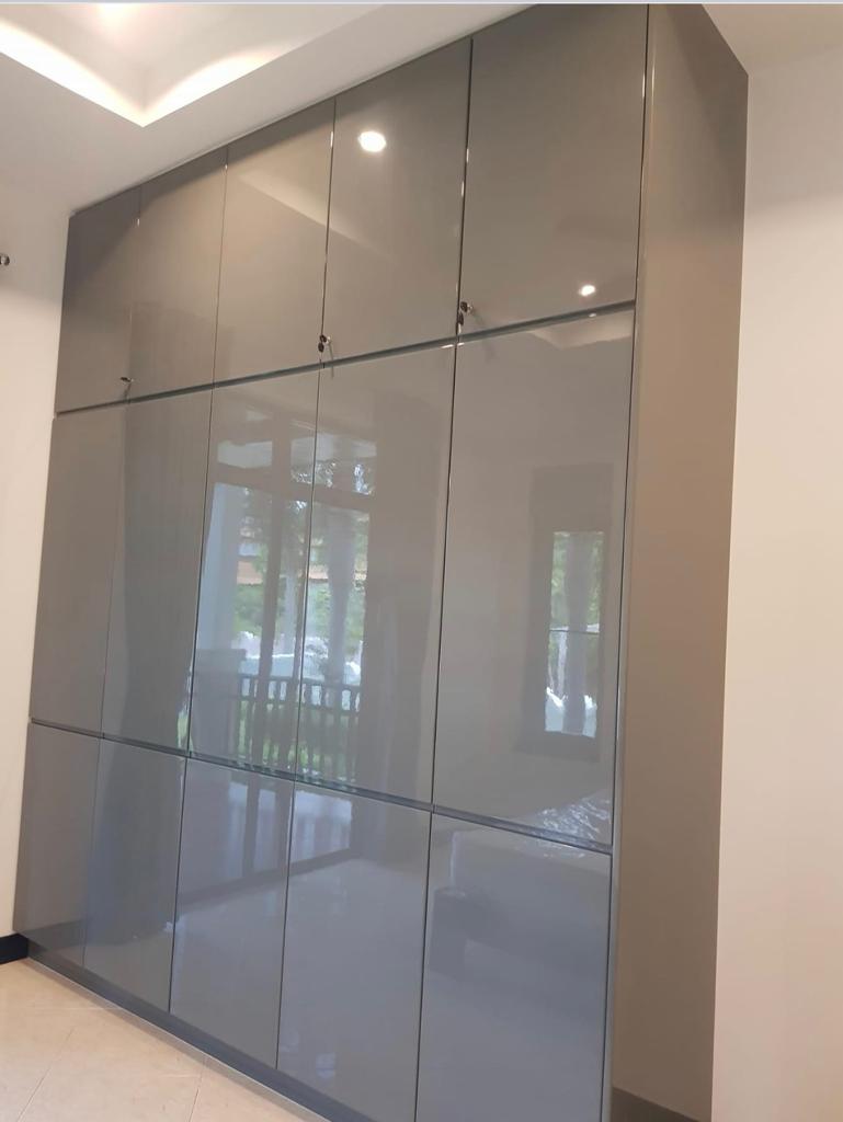 Floor-to-ceiling custom wardrobe with high-gloss gray finish and handleless design