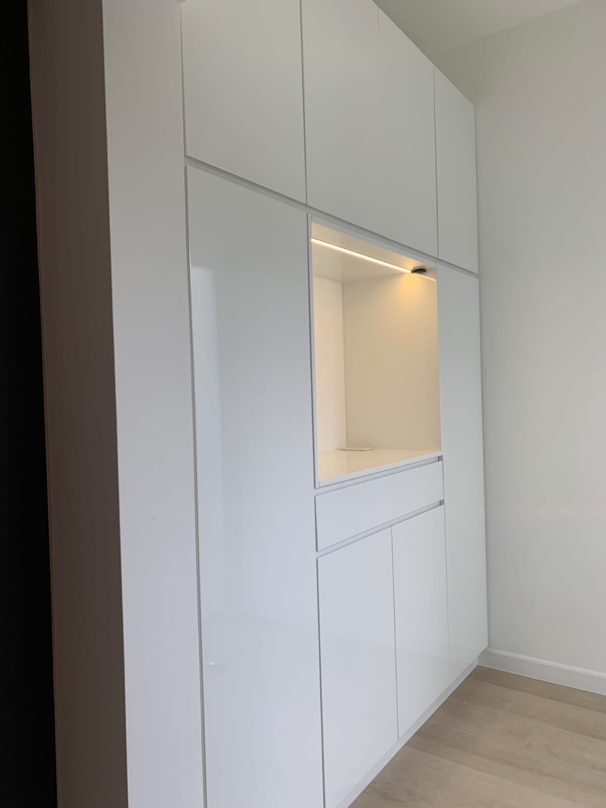 Custom entrance cabinet with clean white finish and integrated LED lighting