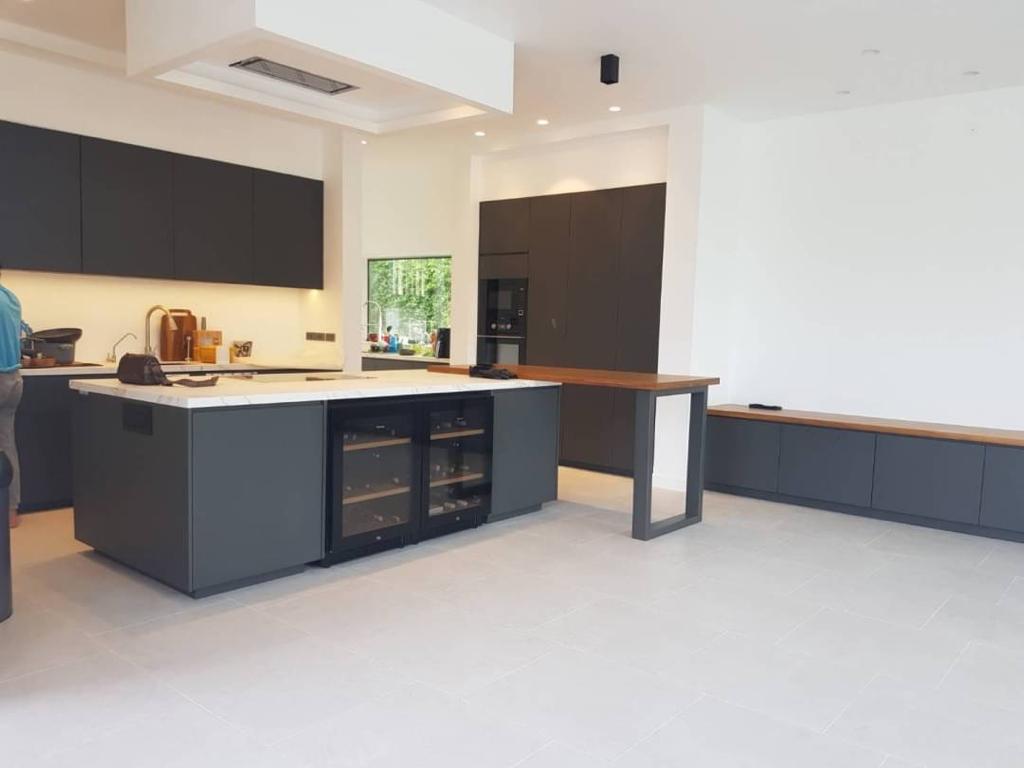 Modern minimalist kitchen with navy blue cabinets and white quartz countertops
