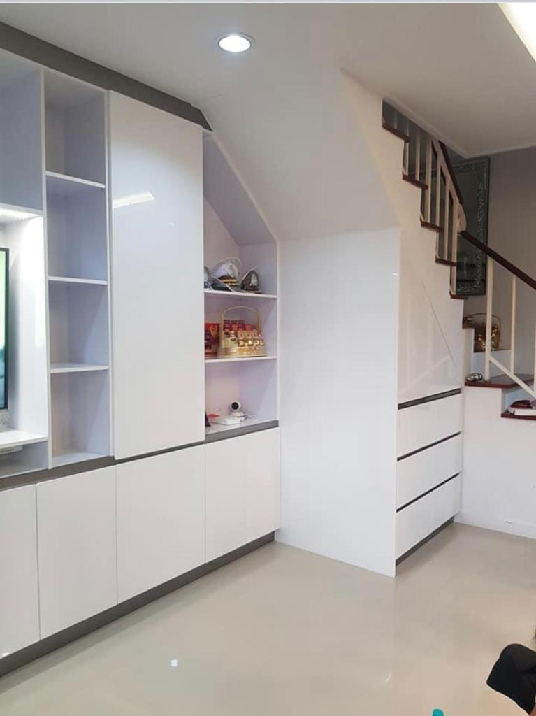Under-stair storage solution with white custom cabinetry and LED lighting