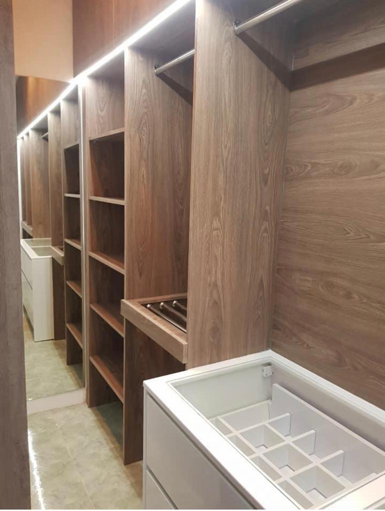 Walk-in closet with custom wood cabinetry and extensive storage solutions