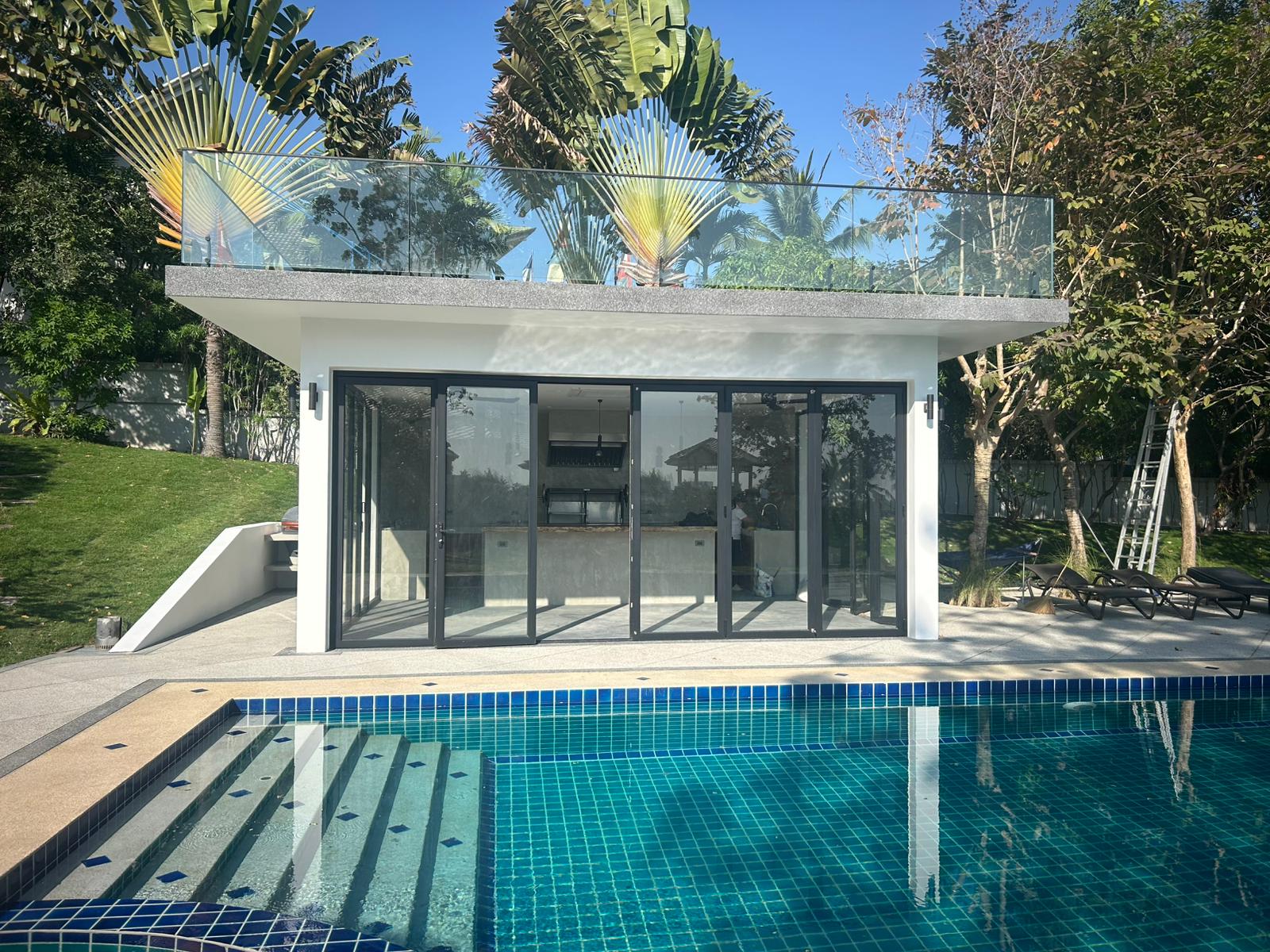 Modern BBQ pavilion with folding bay windows and pool view